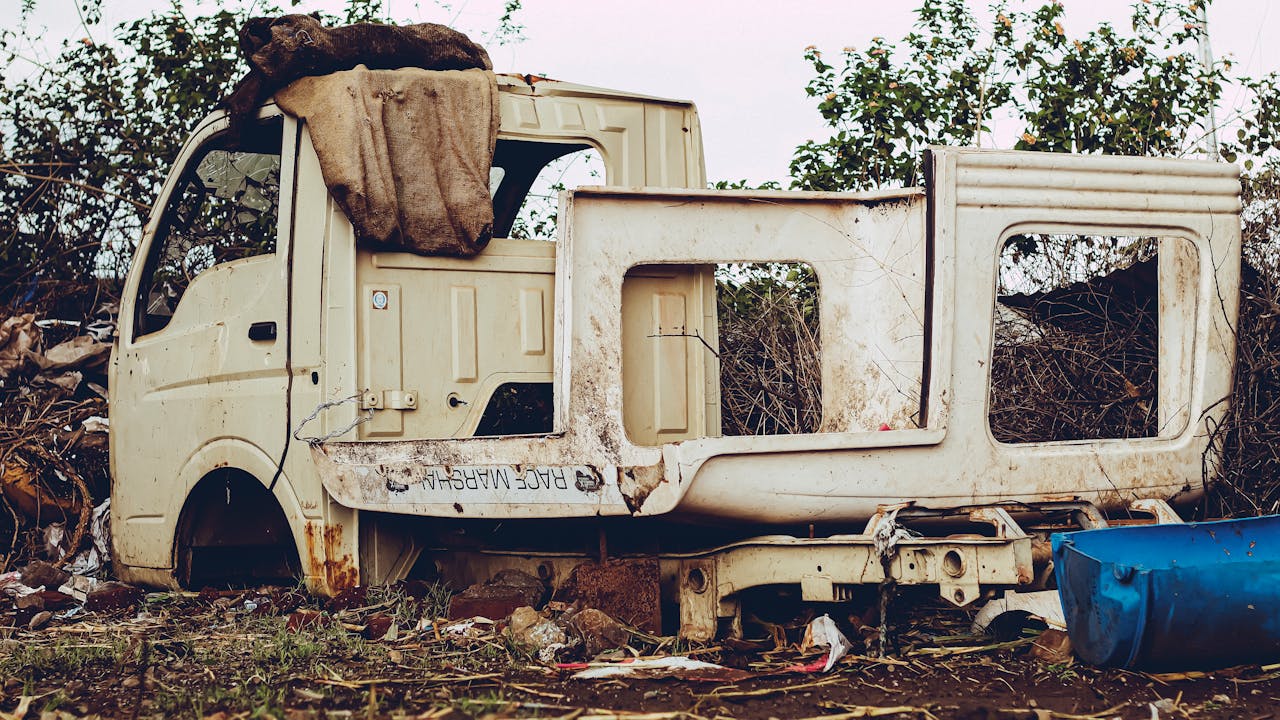 An old, rusty vehicle shell left abandoned in the suburbs of Pune, India.